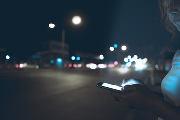 Asian woman play smartphone side road at night,Thailand people