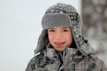 Obraz premium Close-up portrait of a cute boy wearing winter hat and jacket