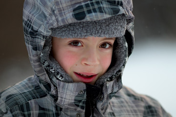 Close-up portrait of a cute boy wearing winter hat and jacket