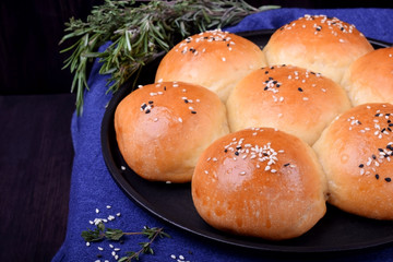 Golden round buns for burgers topped with sesame seeds 