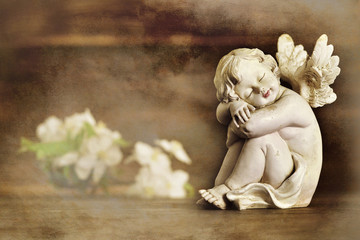 Angel and flowers on wooden background