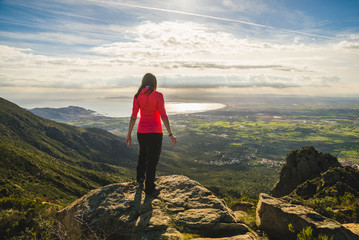 Naklejka premium Girl on top of a cliff watching a beautiful landscape