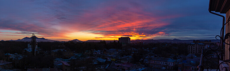 Panorama sleeping city in the bright yellow-red dawn