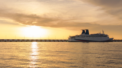 Fototapeta na wymiar Sea cruise ship moored in the harbor at sunset.