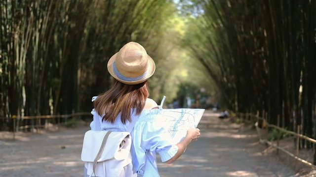 Young woman traveler searching direction on location map while traveling