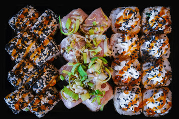 Sushi set. Appetizing, varied sushi on a stone plate. Composition on a dark background.