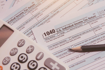 Fototapeta premium Tax season. calculator, pencil on 1040 tax form background