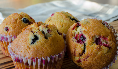 Muffins with red and black currant. paper bakeware with Valentine's day design with pink hearts. Close up, angle view