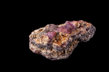 Macro pink Smithsonite mineral stone on microcline on black background