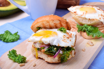 Sandwich with fried egg and salad with kale
