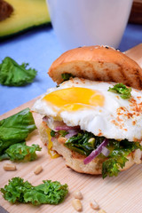 Sandwich with fried egg and salad with kale