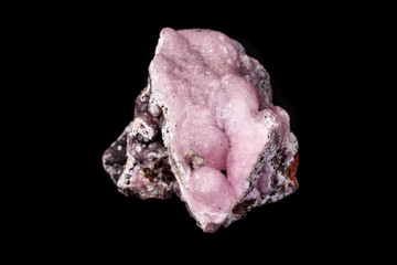 Macro pink Smithsonite mineral stone on microcline on black background