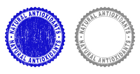Grunge NATURAL ANTIOXIDANTS stamp seals isolated on a white background. Rosette seals with grunge texture in blue and gray colors.