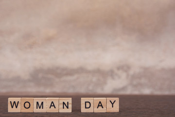 Woman day text with alphabet wooden block cube on table dark plank wooden background with copy space