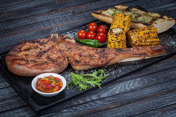  juicy, fried, tender steak with vegetables and sauces on a special stand