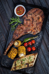  juicy, fried, tender steak with vegetables and sauces on a special stand