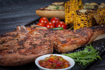 juicy, fried, tender steak with vegetables and sauces on a special stand