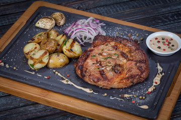  juicy, fried, tender steak with vegetables and sauces on a special stand