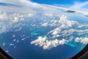 View airplane window with distant isles and atolls