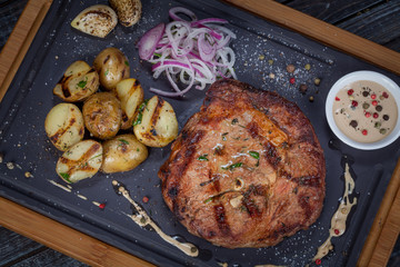  juicy, fried, tender steak with vegetables and sauces on a special stand
