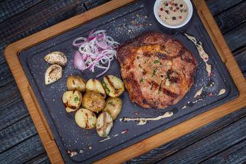  juicy, fried, tender steak with vegetables and sauces on a special stand