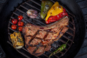  juicy, fried, tender steak with vegetables and sauces on a special stand