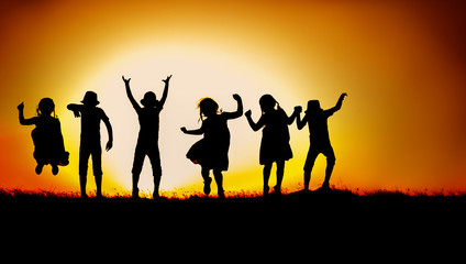 Fototapeta na wymiar Silhouette of happy children boys and girls jumping and dancing in sunset sky evening time background as successful, happiness and careless concept