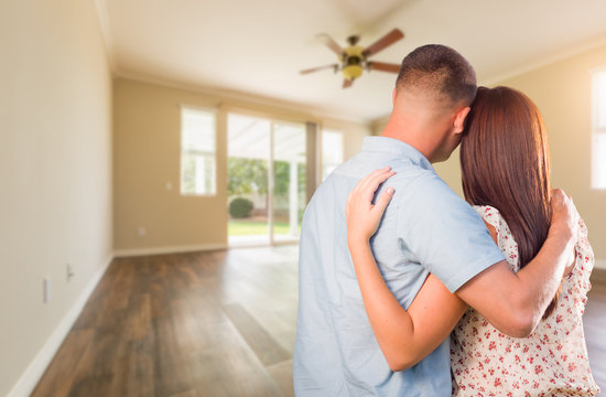 Young Military Couple Looking At Empty Room of New House