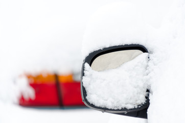 Rearview mirror of a car covered by snow