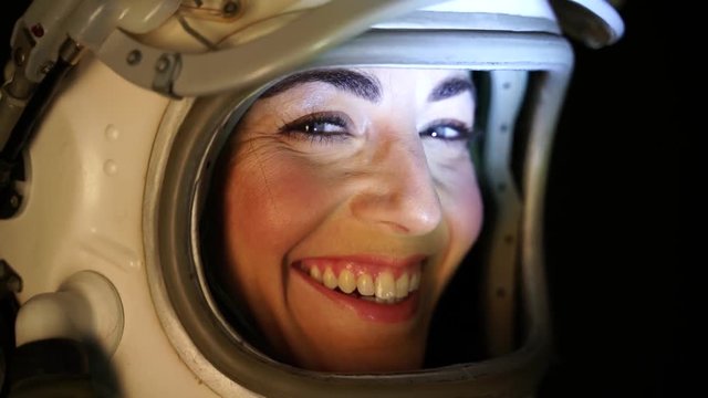 Close up shot of astronaut woman with the helmet visor up relaxing and breathing deep