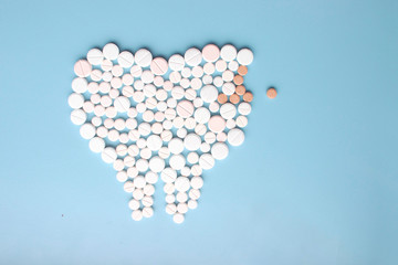 Tooth with caries made of pills. Dental clinic concept.