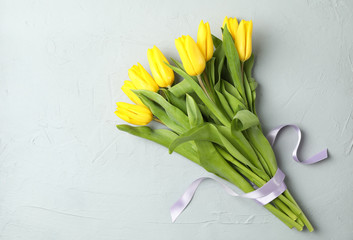 Beautiful fresh yellow tulips on gray background, top view. Space for text