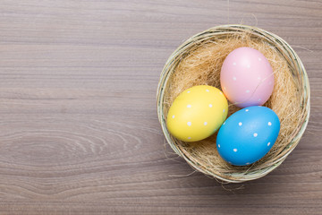 Easter eggs in the basket on wooden background