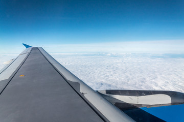 Fototapeta na wymiar view from airplane window blue sky airplane wing white clouds