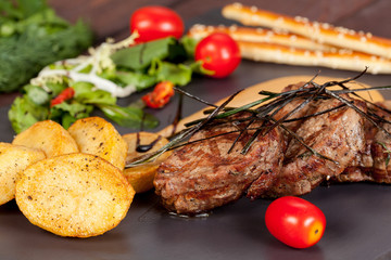  juicy, fried, tender steak with vegetables and sauces on a special stand