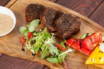  juicy, fried, tender steak with vegetables and sauces on a special stand