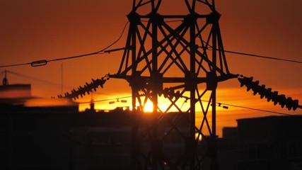 Sunset behind power line silhouette in city.  4K UHD timelapse.