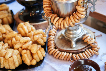 Russian traditional painted samovar with delicious herbal tea and donuts