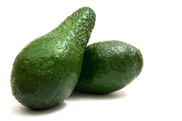 two green ripe avocados close-up on white background