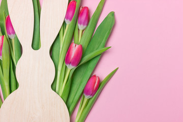 Easter banner with wooden bunny figure and purple fresh tulips