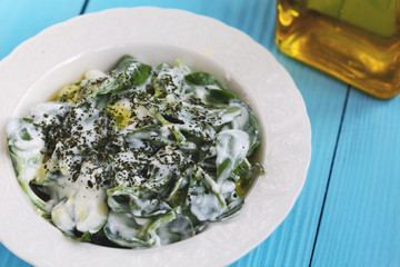 Purslane salad with yogurt on wooden background