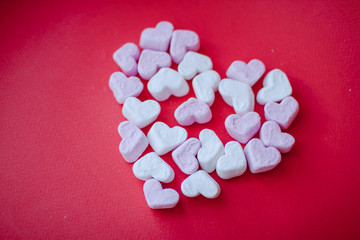 Sweets in the shape of a heart on a red background. Valentine's Day