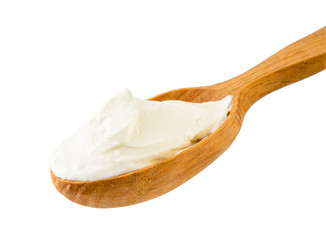 Sour cream in wooden spoon close - up on a white. Isolated.