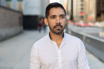 Fototapeta premium Young Latino Hispanic man in city walking street