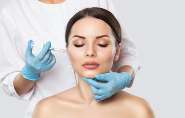 The doctor cosmetologist makes the Rejuvenating facial injections procedure for tightening and...