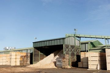 Wood chips pellets chopped wooden logsand stacked wooden pallets for biomass fuel at sawmill