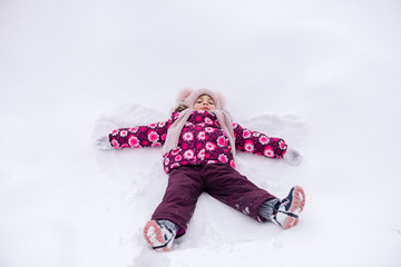 Toddler girl in pink male snow angel
