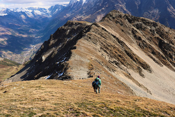 Hiker walking down mountain ridge.