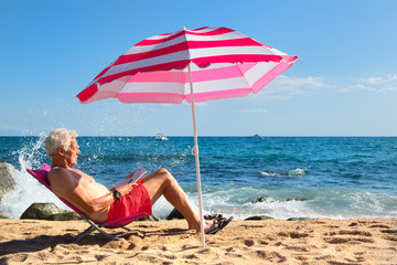 Beach senior man under parasol © Ivonne Wierink