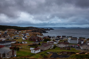 Fototapeta na wymiar Beautiful view of a small town on the Atlantic Ocean Coast during a cloudy evening. Taken in Crow Head, North Twillingate Island, Newfoundland and Labrador, Canada.